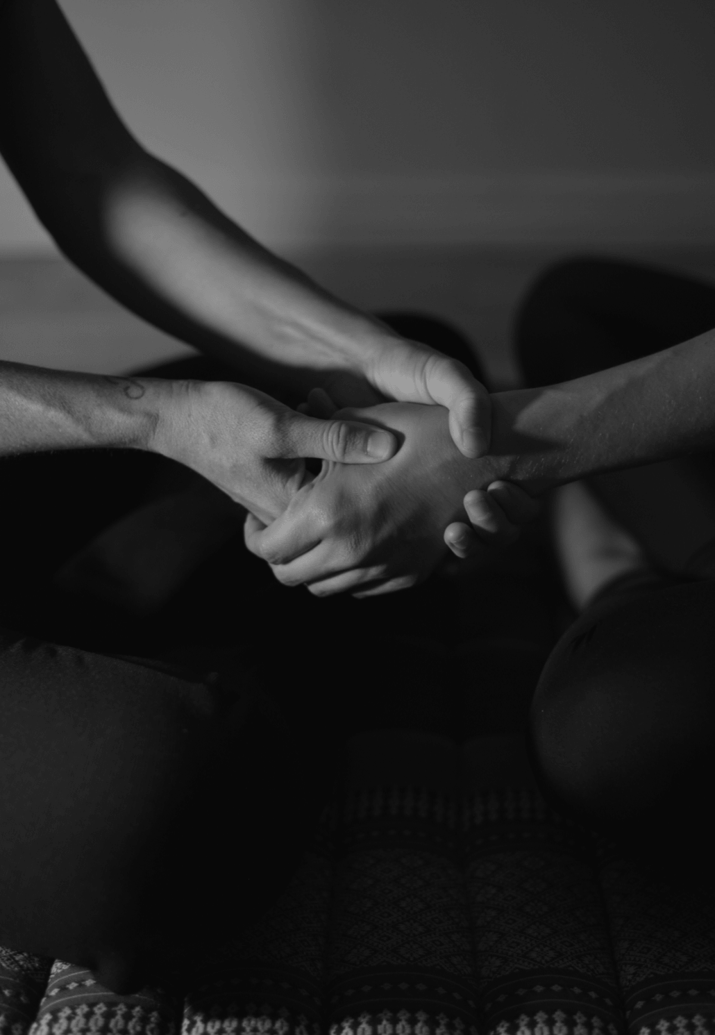 Hands applying supportive pressure around a client's foot